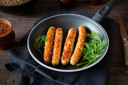 A horizontal photo of Fried sausages in a black panの写真素材