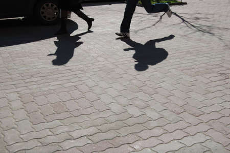 woman and man shadows on sidewalkの写真素材