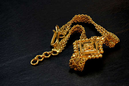 macro of hand worked gold bracelet on black backgroundの写真素材