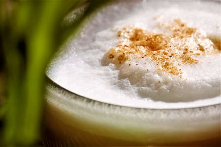 Close up of cappuccino coffee with cinnamon in glass cup