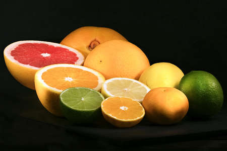 Still life of citrus fruits on black background with grapefruit, orange, lemon, lime and tangerineの写真素材