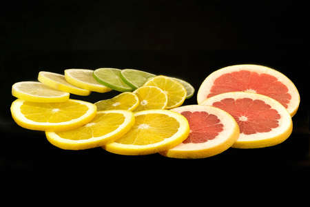 Still life of citrus fruits on black background with grapefruit, orange, lemon, lime and tangerineの写真素材