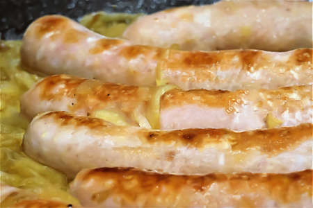 Close up of sausages with wine in casserole with onionの写真素材