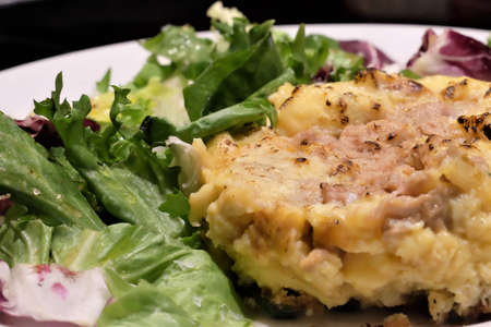 Tuna omelette on plate with lettuce and chicory salad on black backgroundの写真素材