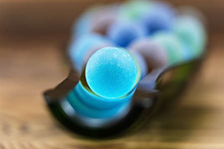 Cut bottle with colored glass marbles on wooden backgroundの写真素材