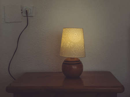 Lit lamp on the bedside tableの写真素材