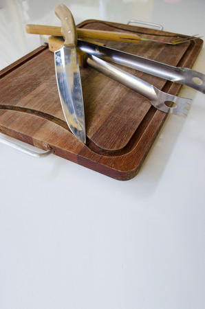 Empty chopping board with a sharp paring knife, fork and catcher on a blank wooden tableの写真素材