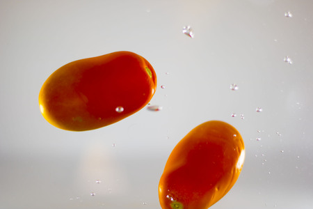 Tomatoes dipping in waterの写真素材