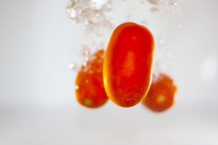 Tomatoes dipping in waterの写真素材