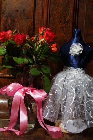 Red roses bouqet on the vintage old wooden piano and balerina dummy - Verticalの写真素材