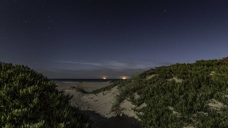 Moon lite beach with sand and hillsの写真素材