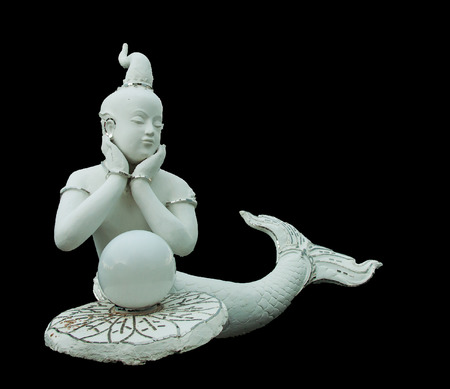 The child mermaid statue in Thai literature is made of white concrete and adorned with beautiful glass,iso late on blackground with  .の写真素材