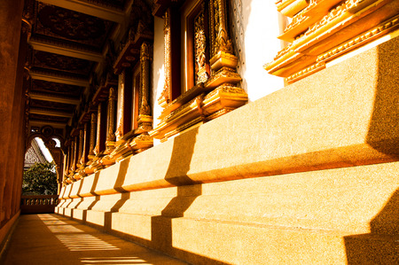 The silhouette of Thai architectural pillars over the sandy corridor.の写真素材