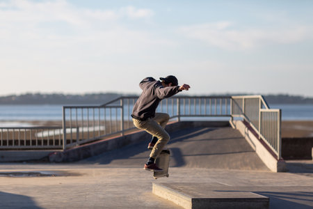 young man jumping on skateboard in a skateparkの写真素材