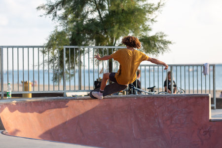 young man jumping on skateboard in a skateparkの写真素材