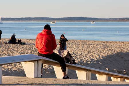 man sitting on a bench looks at the seaの写真素材