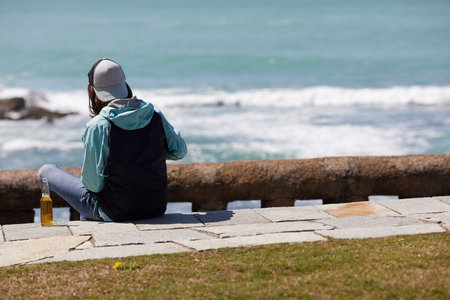 young man picnicking by the sea a sunny day