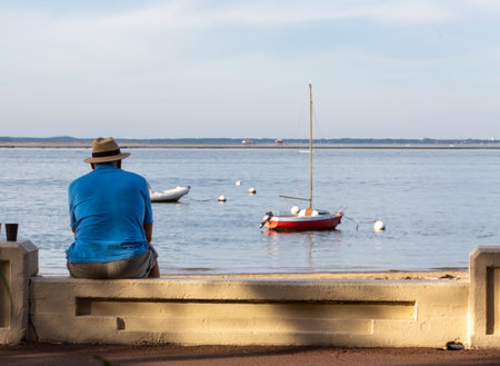 people sitting on a bench looking at the seaの写真素材