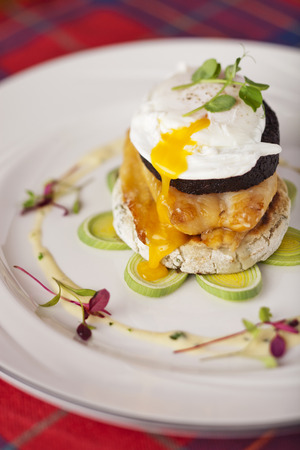 Stornoway black pudding smoked Scottish haddock poached egg on potato scone with cream leekの写真素材
