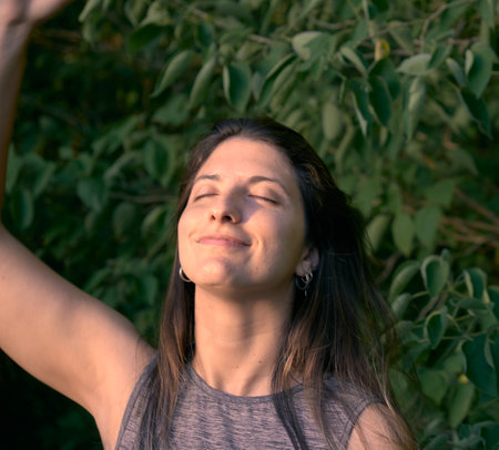 a portrait of a woman model grabbing her hair in the forestの写真素材