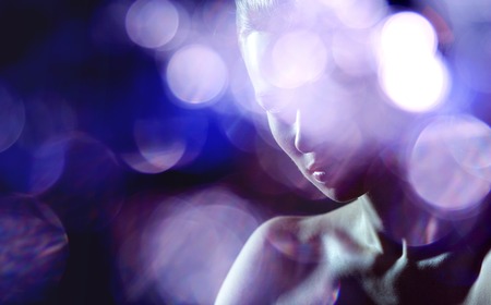 young beautiful girl looking at the camera, dark roomの写真素材