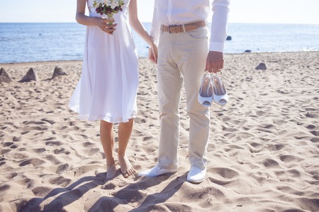 Just married couple running on a sandy beachの写真素材