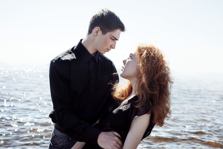 beautiful young couple hugging standing in the seaの写真素材