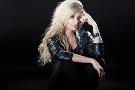 Beautiful and stylish young blonde girl on blackの写真素材