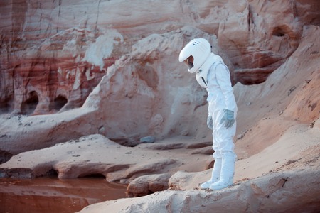 futuristic astronaut on another planet, sandy red planetの写真素材