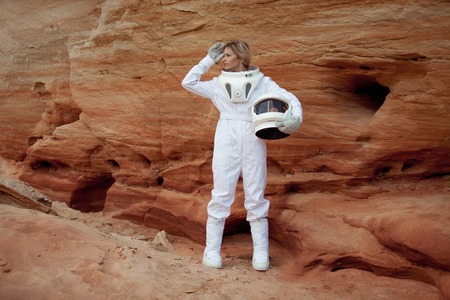 futuristic astronaut on another planet, sandy red planetの写真素材