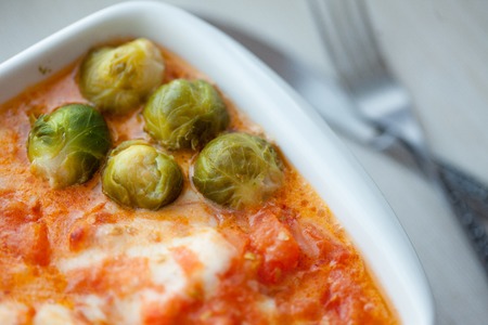 Fish stew, red fish in sauce with Brussels sproutsの写真素材