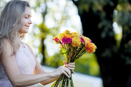 Young beautiful woman florist. The girl in the Park draws a bouquetの写真素材