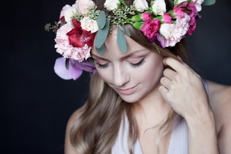 portrait of young beautiful woman in wreath of flowersの写真素材