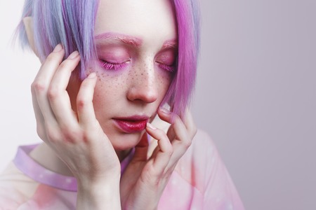 a young girl with pink eyes and hair, like a dollの写真素材