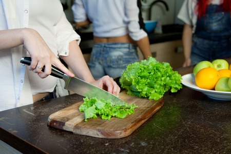 hand of a woman housewife preparing dinner,  lettuce on a cutting boardの写真素材