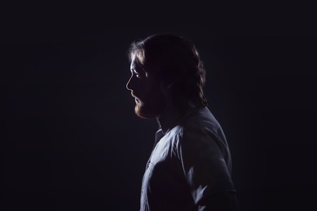 Man with a beard, profile  on a dark background.の写真素材