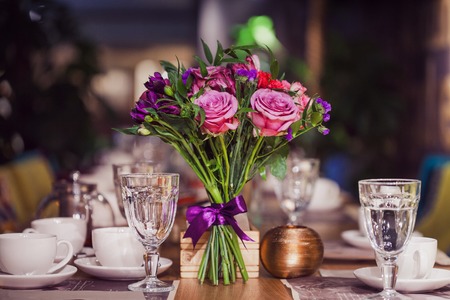 Flowers composition in restaurant,  roses and irises, combination of shades of purpleの写真素材