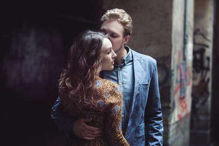 Man hugs a woman. The girl looks over the shoulder of a partnerの写真素材