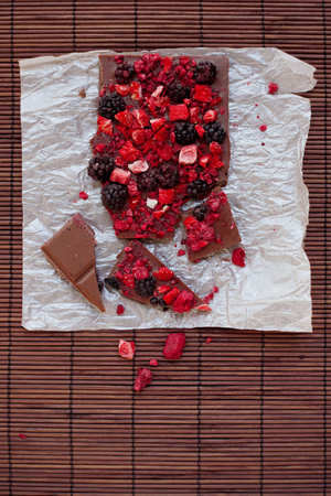 Handmade chocolate with fresh and dried berries, raspberries, strawberries, black currants, blackberries, cocoa powderの写真素材