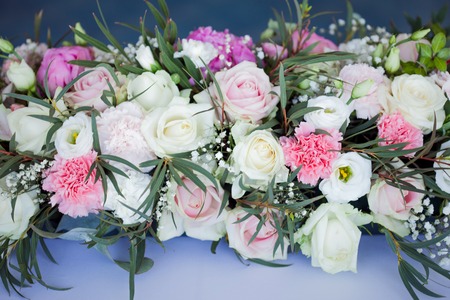 Flower arrangement on the table. Flowers on a white tablecloth, roses and peoniesの写真素材