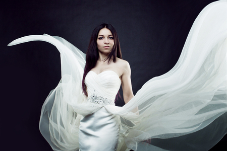 Portrait of girl in long white dress, mystical, mysterious style, dark backgroundの写真素材
