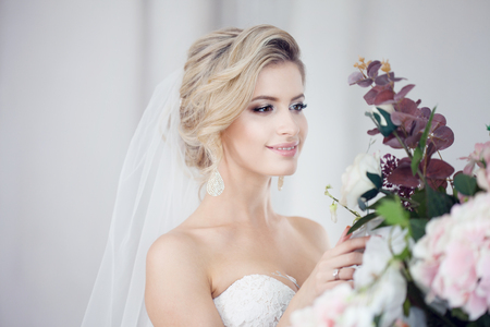 Charming young bride in luxurious wedding dress. Pretty girl in photo Studio, wedding photographyの写真素材