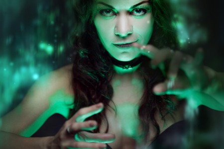 Halloween. Witch creates magic. Beautiful and sexy woman with a mystical light