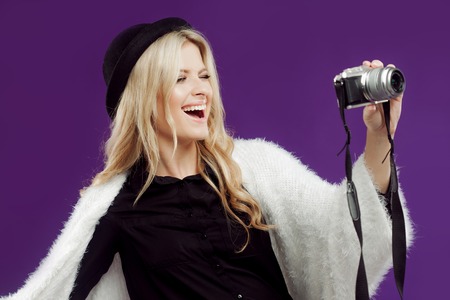 Fashion young girl makes photo. Purple background.の写真素材