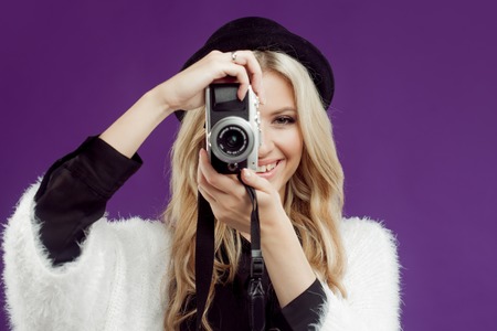 Fashion young girl makes photo. Purple background.の写真素材