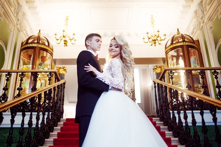 Beautiful young couple, bride and groom. Luxurious light interiorの写真素材