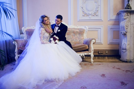 Beautiful young couple, bride and groom. Luxurious light interiorの写真素材