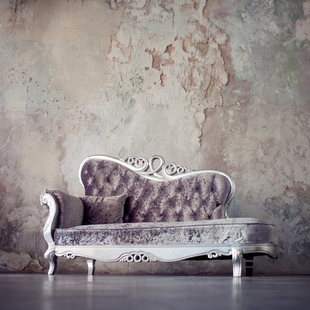 Beautiful sofa in classical style on a background of textured wallsの写真素材