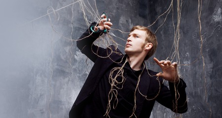 Young man in a black suit got caught in the web.の写真素材