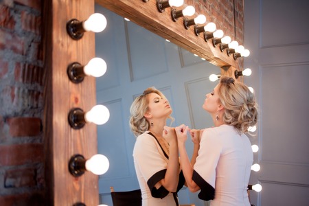 Attractive woman in evening dress, the reflection in the mirror in the backgroundの写真素材